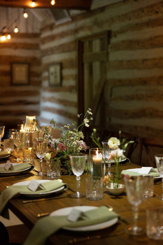 Detail photo of a wedding dinner table with whimsical florals and candles