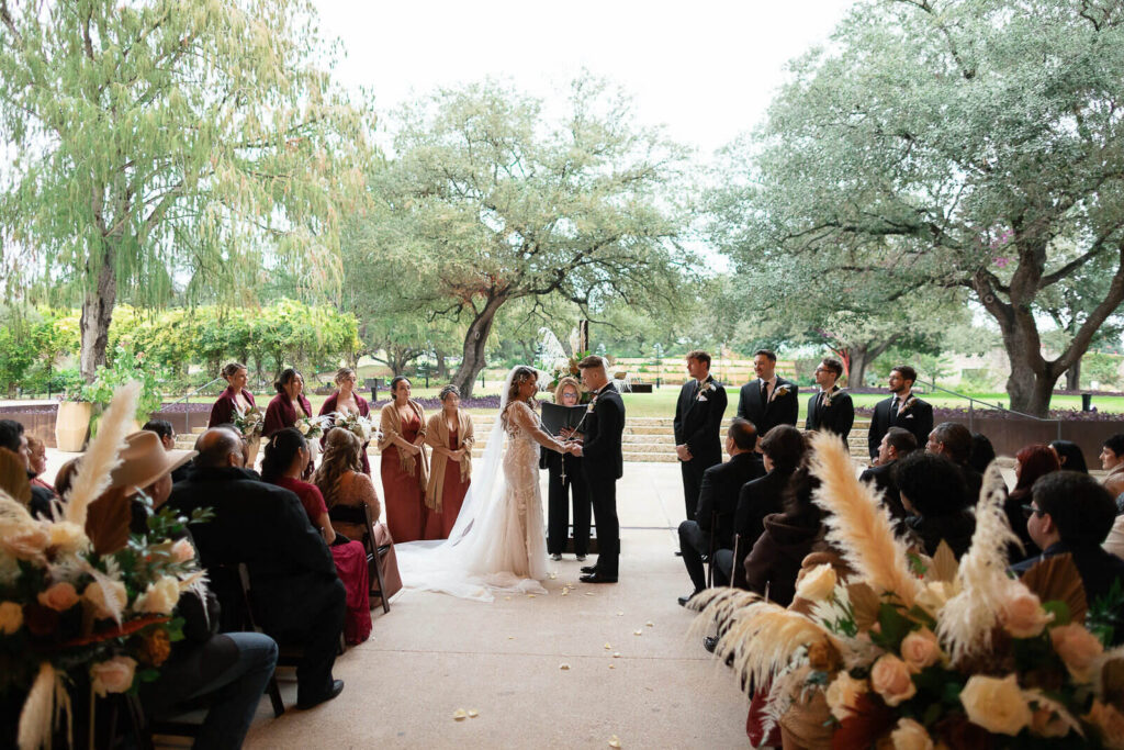 A rustic boho wedding ceremony in the shade of Betty Kelso Center at The San Antonio Botanical Garden