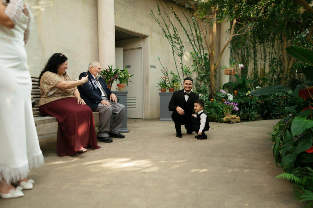 Candid moment of a bride, groom, and their family inside the Napier Family Orchid Pavilion