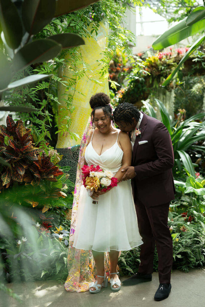 A bride and groom standing in the orchid pavilion