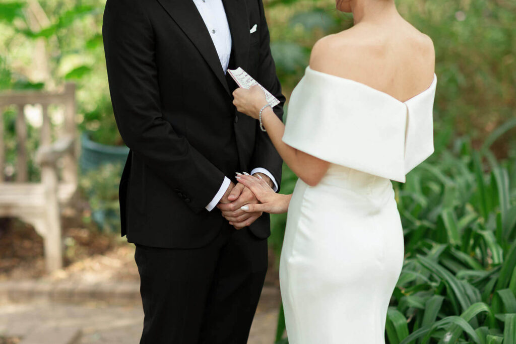 Close up of a bride and grooms hands during their private vow exchange
